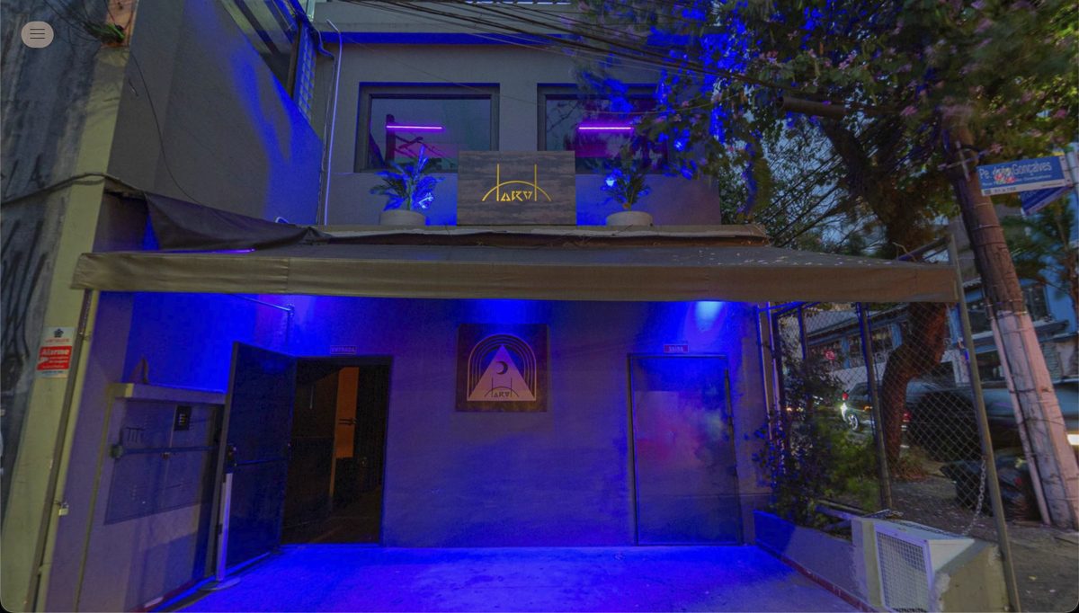 Fachada do TAROT iluminada de azul à noite